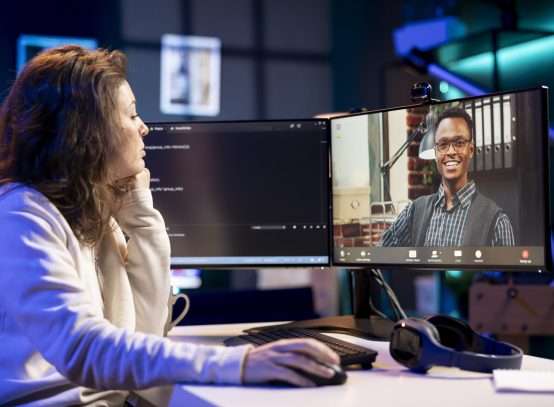 Admin doing company software debugging, talking with management in videocall about errors found in code. IT employee sharing coding mistakes found with board of directors in online teleconference